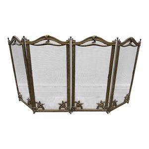 May include: A four-panel folding fireplace screen made of antique brass-toned metal. The frame features a textured wood-grain finish with decorative turtle motifs at the base of each vertical support and a curved top rail with fine mesh panels.