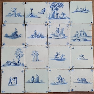 Puede incluir: Una colección de dieciséis azulejos de cerámica cuadrados dispuestos en una cuadrícula de cuatro por cuatro. Cada azulejo de color blanco roto presenta una ilustración azul única pintada a mano con diversas escenas pastorales y figuras.