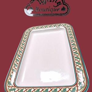 May include: A rectangular white serving platter with a decorative border. The border features a teal, gold, and burgundy pattern. The platter has rounded corners and is set against a burgundy background. The text "Tiffany Boutique" is at the top.
