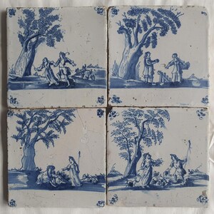 Puede incluir: Cuatro baldosas de cerámica cuadradas con una escena pastoral azul y blanca. Cada baldosa representa figuras, árboles y paisajes. Las baldosas están dispuestas juntas, creando una imagen más grande de un entorno rural.
