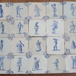 Puede incluir: Una colección de veintiuna baldosas de cerámica antiguas. Cada baldosa cuadrada presenta una ilustración en azul y blanco pintada a mano de una persona con ropa de época. Las baldosas están dispuestas juntas, mostrando una variedad de figuras y poses.