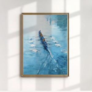 May include: A framed painting of a rowing team in a blue boat on blue water. The artwork has a gold frame and a light blue and white colour palette. The rowers are wearing yellow and blue uniforms.