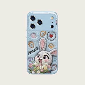 May include: A light blue phone case with a fluffy texture, featuring a cartoon bunny holding flowers. The case has a cute design with embroidered paw prints, hearts, and the word "mua".