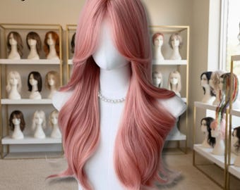 Puede incluir: Una peluca larga y ondulada de color rosa sobre un maniquí. La peluca tiene un estilo en capas con flequillo y un collar de perlas. El texto "Wig Landia" está en la esquina superior izquierda. Otras pelucas son visibles en el fondo.