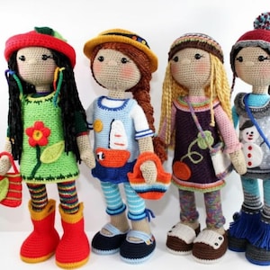Peut inclure: Quatre poupées crochetées à la main, chacune avec des tenues et des accessoires uniques. L'une porte une robe verte avec une fleur, une autre une tenue de marin bleue, une troisième une robe violette et la dernière une tenue d'hiver avec un bonhomme de neige. Les poupées mesurent environ 30 cm.