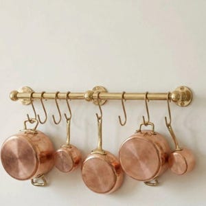 Puede incluir: Un juego de tres tazas de cerámica con un acabado mate moteado. Las tazas son en tonos azul, verde y blanco. Cada taza tiene un asa redondeada y un diseño simple y moderno. Para café o té.