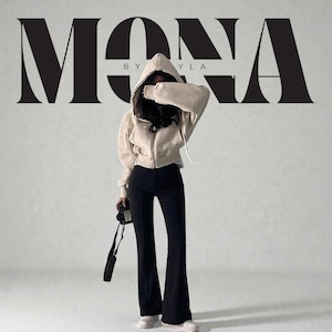 Op de afbeelding: Een vrouw draagt een beige hoodie met rits, een zwarte flared broek en witte sneakers. De afbeelding toont de tekst "MONA BY YLA" in een vetgedrukte, gestileerde lettertype. Een camera wordt in de hand van de vrouw gehouden.