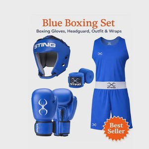 Op de afbeelding: Een blauwe boksset met de tekst Blue Boxing Set, Boxing Gloves, Headguard, Outfit & Wraps. De set bevat een blauwe hoofdbeschermer met het Sting-logo, een paar blauwe bokshandschoenen, twee blauwe bandages, een blauwe tanktop en een korte broek.