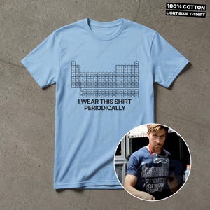 K&ouml;nnte beinhalten: Hellblaues T-Shirt mit Periodensystem-Grafik und dem Text "I WEAR THIS SHIRT PERIODICALLY". Hergestellt aus 100% Baumwolle.