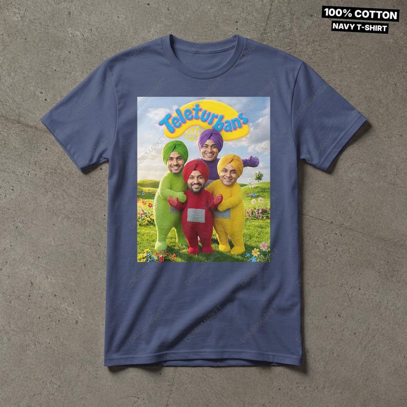 Pode incluir: Uma t-shirt azul-marinho com uma estampa gr&aacute;fica de quatro figuras em trajes coloridos com turbantes, em p&eacute; num campo relvado sob um c&eacute;u azul. O texto acima das figuras diz Teleturbans. A t-shirt &eacute; feita de 100% algod&atilde;o.
