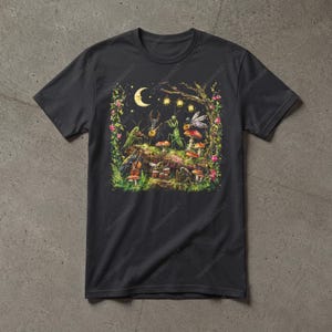 Può includere: Una t-shirt nera a maniche corte con una stampa grafica colorata di vari insetti che suonano strumenti musicali su un tronco coperto di muschio. La scena include una luna crescente, lanterne sospese e funghi rossi tra fogliame verde.