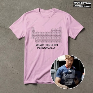 K&ouml;nnte beinhalten: Hellrosa T-Shirt mit dem Text "I WEAR THIS SHIRT PERIODICALLY" unterhalb einer schwarz-wei&szlig;en Periodentafel. Das Shirt besteht aus 100% Baumwolle.