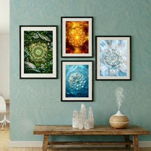 Op de afbeelding: Vier ingelijste kunstprints met mandala-ontwerpen in verschillende kleuren hangen aan een turquoise muur. Onder de kunstwerken staat een houten bank met decoratieve items. De kamer heeft een lichte houten vloer en een raam met witte gordijnen.