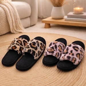 Peut inclure: Deux paires de pantoufles à bout ouvert avec semelles noires et dessus en fausse fourrure à imprimé léopard. Une paire présente des taches marron et beige, l'autre rose et marron. Les pantoufles sont présentées sur un tapis tissé.