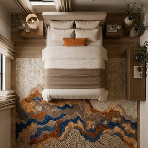 Puede incluir: Un dormitorio con una cama de ropa de cama color crema, una manta marr&oacute;n y un coj&iacute;n lumbar naranja. El suelo est&aacute; cubierto por una alfombra grande con un patr&oacute;n de paisaje abstracto y texturizado en tonos azul, marr&oacute;n, beige y crema.
