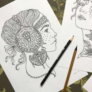 May include: A black and white line drawing of a woman's face with intricate details. The woman is wearing a headband and a large ornate earring. The drawing is on a white background.