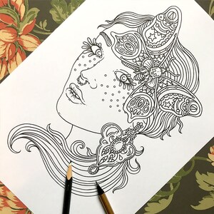 Pu&ograve; includere: Un disegno in bianco e nero di un viso di donna con una farfalla sulla fronte. La farfalla ha dettagli intricati ed &egrave; circondata da stelle. I capelli della donna sono lunghi e fluenti, e lei indossa un delicato orecchino.