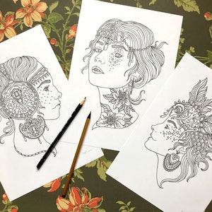 May include: Three black and white printable colouring pages featuring detailed illustrations of women's faces with intricate headwear and floral designs.
