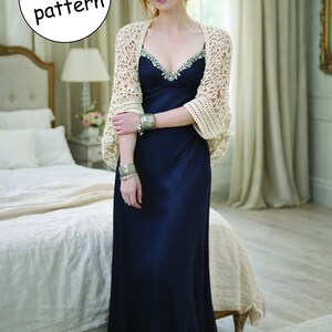 Könnte beinhalten: Eine Frau trägt ein marineblaues Maxikleid und einen cremefarbenen Häkelschal. Der Schal hat ein filigranes Lochmuster. Das Bild enthält den Text "4 in 1 pattern" in einem weißen Kreis.