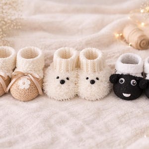 Könnte beinhalten: Eine Auswahl an Baby-Booties in Creme, Beige und Schwarz. Zwei Paar cremefarbene Booties haben Schleifen und florale Akzente. Zwei Paare sind flauschig mit gestickten Bärengesichtern, und zwei Paare sind schwarz mit Schafgesichtern.
