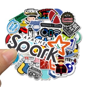 Peut inclure: Un ensemble d'autocollants color&eacute;s avec divers motifs et textes. Les autocollants incluent les mots "Spark" et "Apache", ainsi que d'autres phrases et graphiques li&eacute;s &agrave; la technologie. Une main tient les autocollants sur fond blanc.