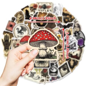 Pu&ograve; includere: Un adesivo a forma di fungo rosso e bianco, alto 5,06 cm e largo 4,94 cm, tenuto in mano. L'adesivo &egrave; circondato da altri adesivi in stile vintage con vari disegni. Il fungo ha un'illustrazione dettagliata.