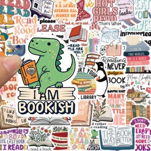 May include: A sticker sheet with various book-themed designs. A green dinosaur sticker holding a book with the text "I AM BOOKISH" is the focal point. Other stickers include books, quotes, and a penguin reading.