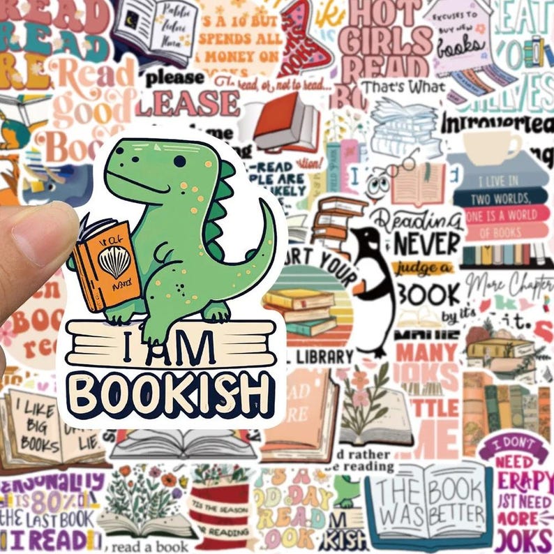 May include: A sticker sheet with various book-themed designs. A green dinosaur sticker holding a book with the text "I AM BOOKISH" is the focal point. Other stickers include books, quotes, and a penguin reading.