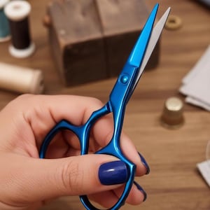 May include: A pair of bright blue scissors with silver blades, held in a hand. The scissors have a heart-shaped handle design. The background includes sewing supplies like thread spools and a thimble, suggesting a crafting theme.