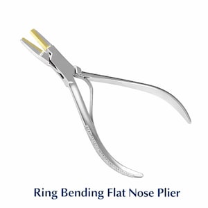 May include: A silver ring bending flat nose plier with gold-colored tips. The tool has curved handles and a textured grip. The text "Ring Bending Flat Nose Plier" is displayed below the tool.