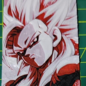 May include: A rectangular, 3D-printed artwork featuring a character with spiky white hair and red accents. The character's face and upper body are depicted in detail, with a black background. The artwork is on a green cutting mat.