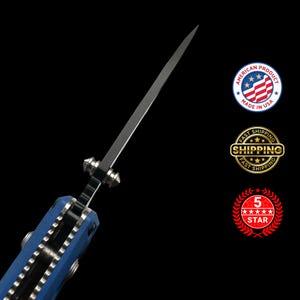 Puede incluir: Un cuchillo plegable parcialmente visible y abierto con una larga hoja plateada. El mango es azul con detalles plateados. La imagen incluye el texto "AMERICAN PRODUCT MADE IN USA" y "5 STAR".
