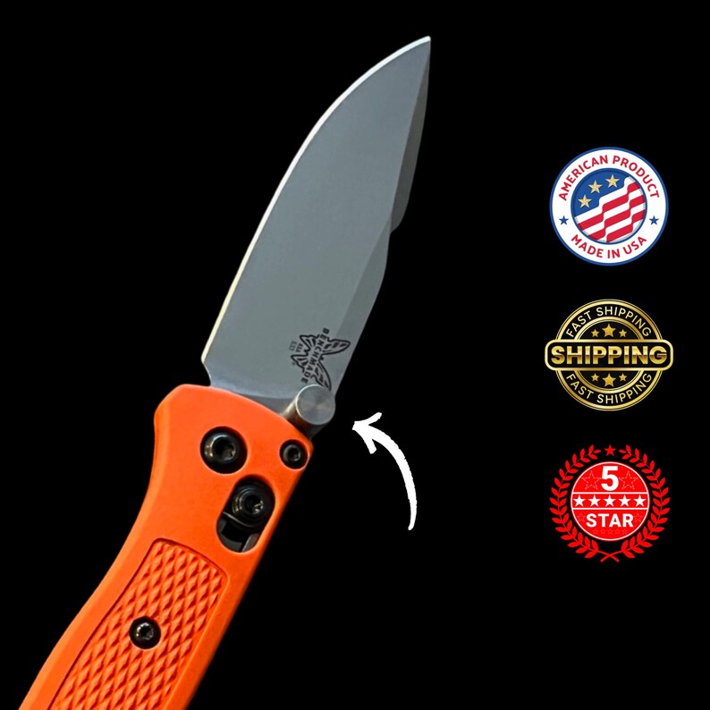 K&ouml;nnte beinhalten: Ein orangefarbenes Klappmesser mit einer silbernen Klinge. Die Klinge hat ein kleines Emblem und ist teilweise ge&ouml;ffnet. Der Griff ist strukturiert und hat schwarze Hardware. Das Messer ist mit "Made in USA" gekennzeichnet.