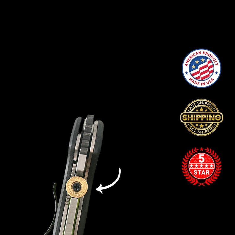 Pode incluir: Close-up de uma faca dobr&aacute;vel preta e prateada com um detalhe dourado. A faca tem um clip de bolso e uma pequena pe&ccedil;a circular dourada com texto. A imagem tamb&eacute;m inclui um selo "Made in USA" e um selo "5 estrelas".