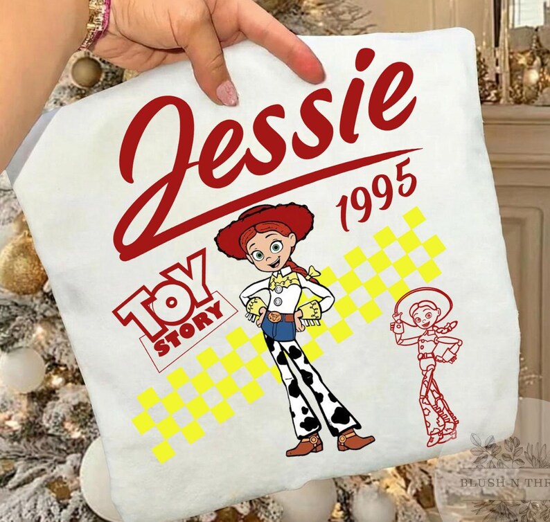 May include: White pillowcase featuring the name "Jessie" in red script above the year "1995". The pillowcase has a "Toy Story" logo and a cartoon image of Jessie the cowgirl. A smaller outline of Jessie is also on the pillowcase.