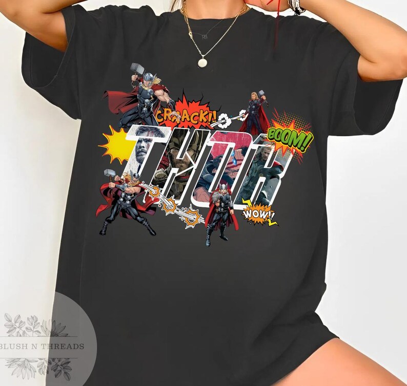 May include: Black t-shirt featuring a comic book style graphic of Thor with the word "THOR" in large, stylized letters. The design includes action bubbles with words like "CRACK!" and "BOOM!"