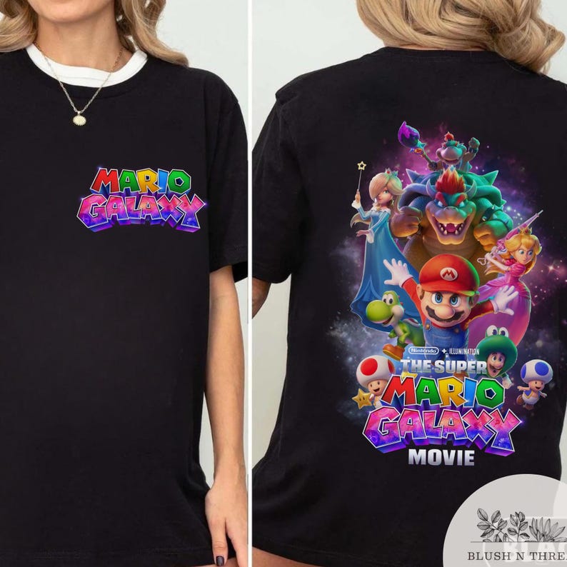 Puede incluir: Camiseta negra con el logo "Mario Galaxy" en la parte delantera y un gr&aacute;fico colorido de Mario y sus amigos de "The Super Mario Galaxy Movie" en la parte trasera. La camiseta tiene cuello redondo blanco.