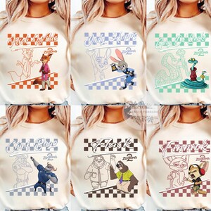 May include: Cream-colored t-shirts featuring characters from the animated movie Zootopia. Each shirt displays a different character's name and image, including Nick Wilde, Judy Hopps, and Finnick, with a checkered pattern.