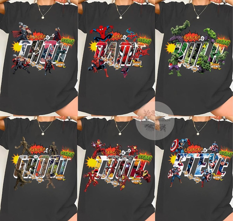 May include: Dark gray t-shirts featuring comic book characters and names. The shirts display the names "THOR", "DAD", "HULK", "GROOT", "IRON MAN", and "STEVE" in a bold, comic-style font, with action graphics and sound effects.