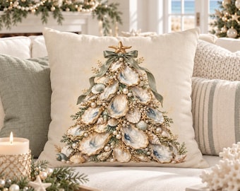 May include: A square throw pillow with a beige linen-like cover featuring a printed graphic of a Christmas tree constructed from various oyster shells, small white pearls, and tiny starfish, topped with a large starfish and a sage green ribbon bow.