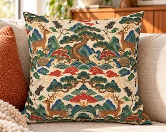 May include: A square throw cushion featuring a cream-coloured background with a repeating pattern of brown deer, white cranes, green pine trees, blue mountains, red clouds, and brown turtles. The design is symmetrical and colourful.