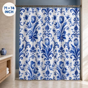 May include: A white shower curtain featuring a repeating blue floral pattern with tulips and intricate scrollwork. The curtain hangs from a metal rod with rings and measures 71 x 74 inches. The design displays a symmetrical botanical motif.