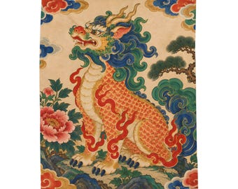 May include: A rectangular wall hanging featuring a mythical creature with a scaly orange body, blue mane, and horns. The creature stands amidst stylised clouds, a pine tree, and a large pink peony flower on a light beige background.