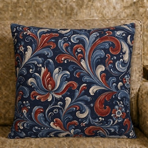 May include: A square throw pillow featuring a dark navy blue background with a repeating pattern of swirling floral and leaf motifs in shades of deep red, light blue, and white. The design covers the entire front surface of the pillow.