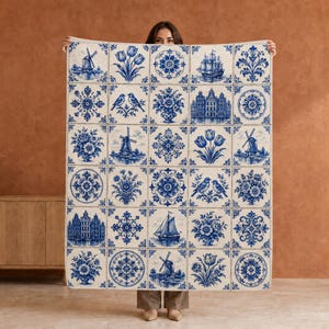 May include: A large rectangular textile featuring a grid of blue and white tiles. The pattern includes illustrations of Dutch windmills, tulips, sailing ships, canal houses, floral motifs, and birds, all rendered in a classic delft blue style.