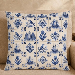 May include: A square throw pillow featuring a grid pattern of blue and white illustrations on a cream background. The design includes depictions of sailing ships, songbirds, tulips, windmills, and traditional Dutch canal houses in a tile style.