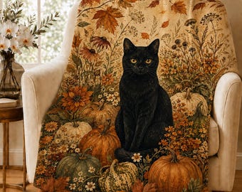 May include: A throw blanket featuring a black cat sitting among orange and green pumpkins, autumn leaves, and wildflowers. The design displays a warm, seasonal color palette with detailed botanical illustrations and a central feline figure.