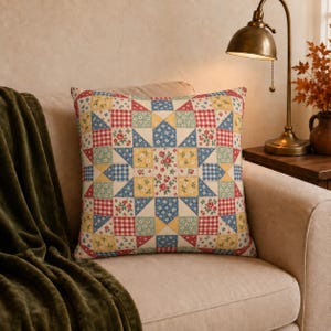 May include: A square throw cushion featuring a patchwork star pattern composed of various fabric squares. The design includes red and white gingham, blue and white floral, and yellow and white floral prints arranged in a geometric star motif.