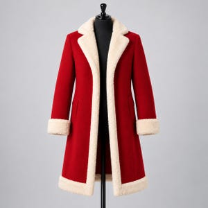 May include: A long, vibrant red coat featuring a thick, cream-colored faux shearling lining along the wide lapels, cuffs, and bottom hem. The coat has a structured silhouette with long sleeves and a straight cut, displayed on a black mannequin.
