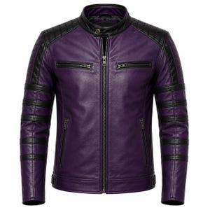 Puede incluir: Una chaqueta de cuero morada con detalles de cuero negro en los hombros y las mangas. La chaqueta incluye un cuello alto con un botón a presión, un cierre de cremallera central, dos bolsillos con cremallera en el pecho y dos bolsillos en la cintura.